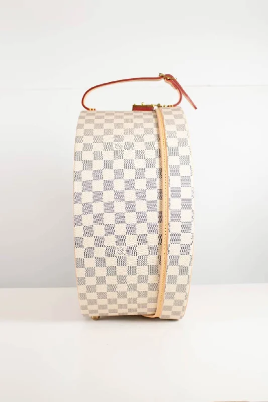 Louis Vuitton Alma bags featuring the signature top - handle designLOUIS VUITTON Damier Azur canvas Boite Chapeaux Hat Box 40 with natural cowhide leather, adjustable top handle and polished brass hardware.